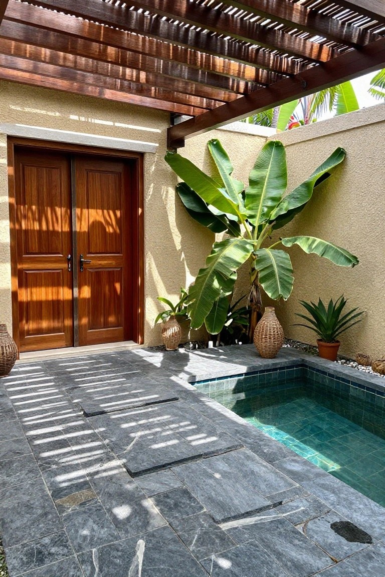 Sunlit stone patio with wooden doors, turquoise pool, banana plant and pergola