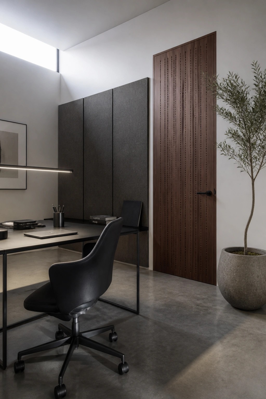 Modern minimalist office with black chair, wooden desk, slatted door, and potted tree.