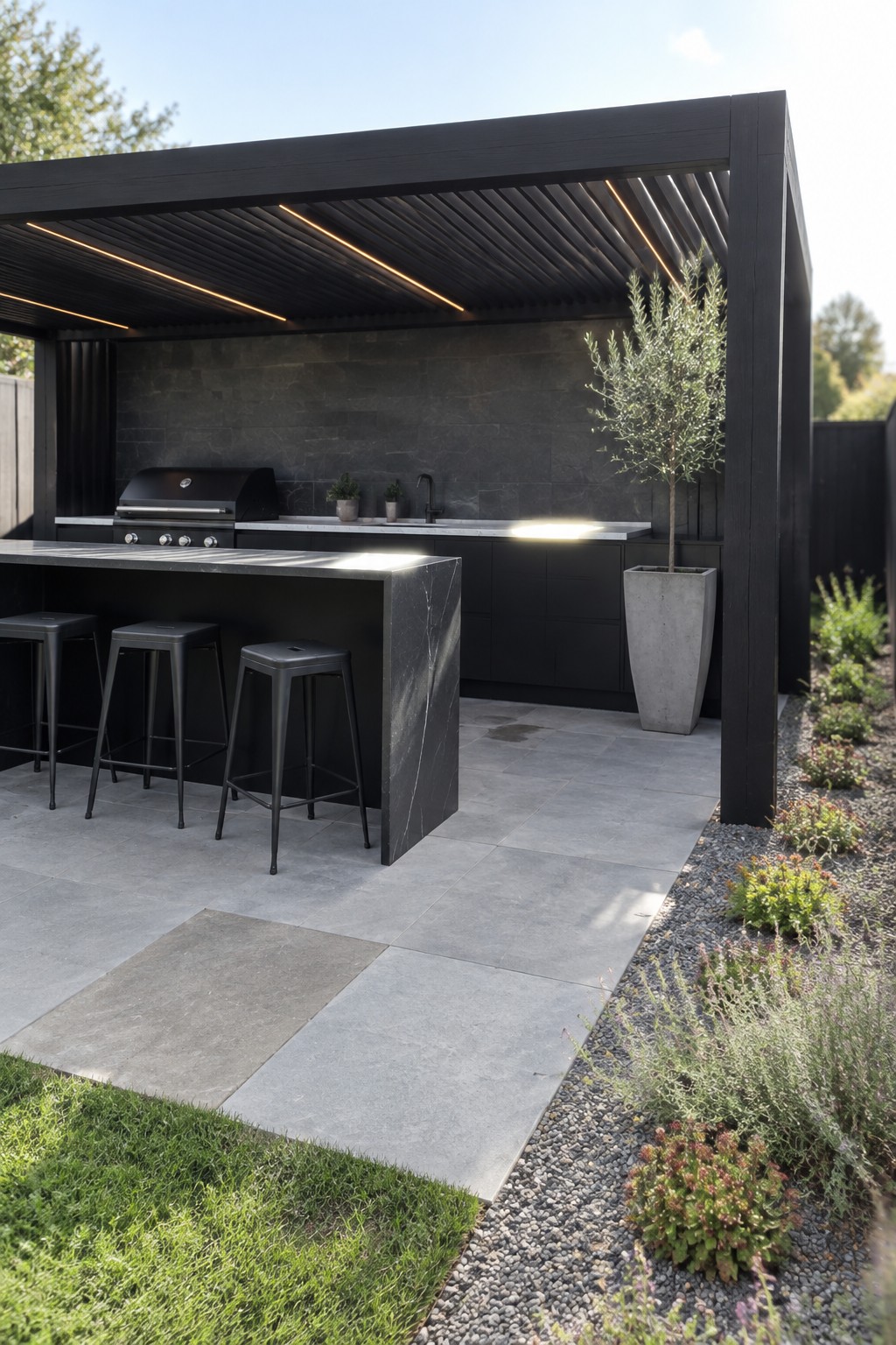 Modern black outdoor kitchen with marble counter, three stools, grill, and potted tree